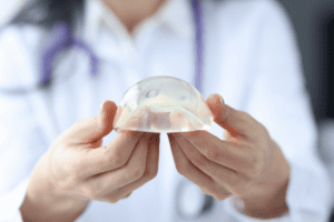 plastic surgeon showing breast implant to patient
