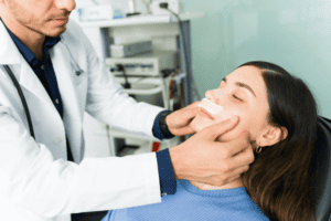 doctor checks patient after nose surgery