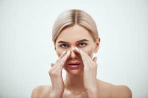 girl treating blackheads on her nose