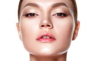 young woman putting on makeup after nose surgery